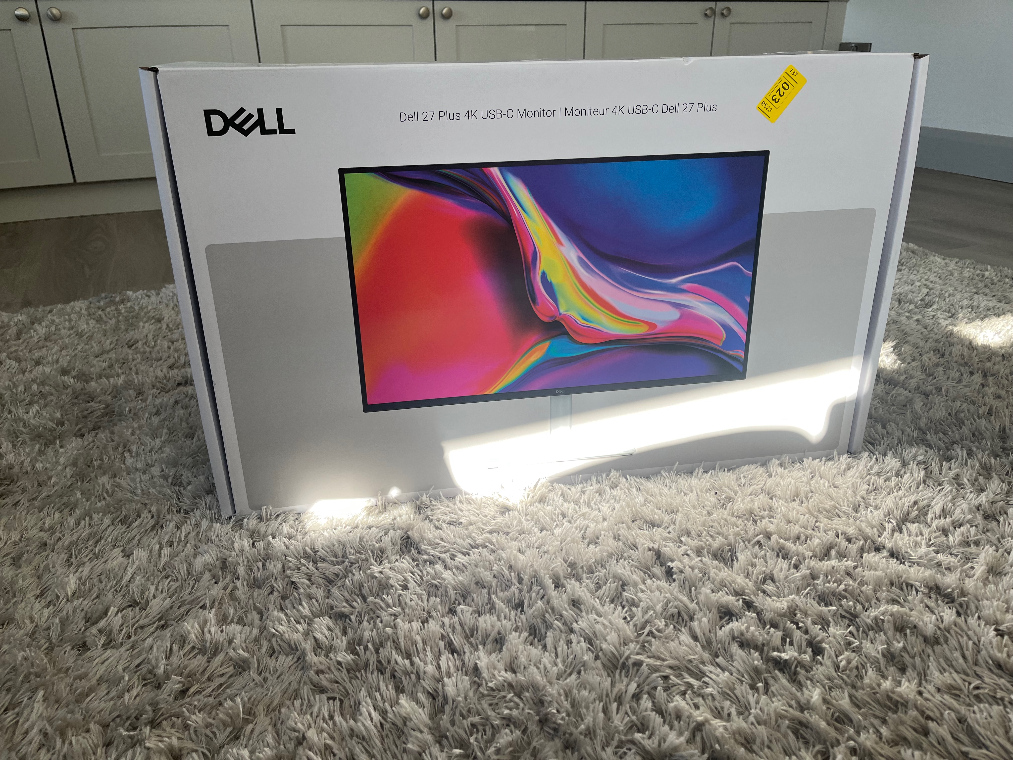 The box for the Dell S2725QC. The box is white and grey, with a pictuer of the monitor on the front. The text above reads "Dell 27 Plus 4K USB-C Monitor", with the French translation alongside it.