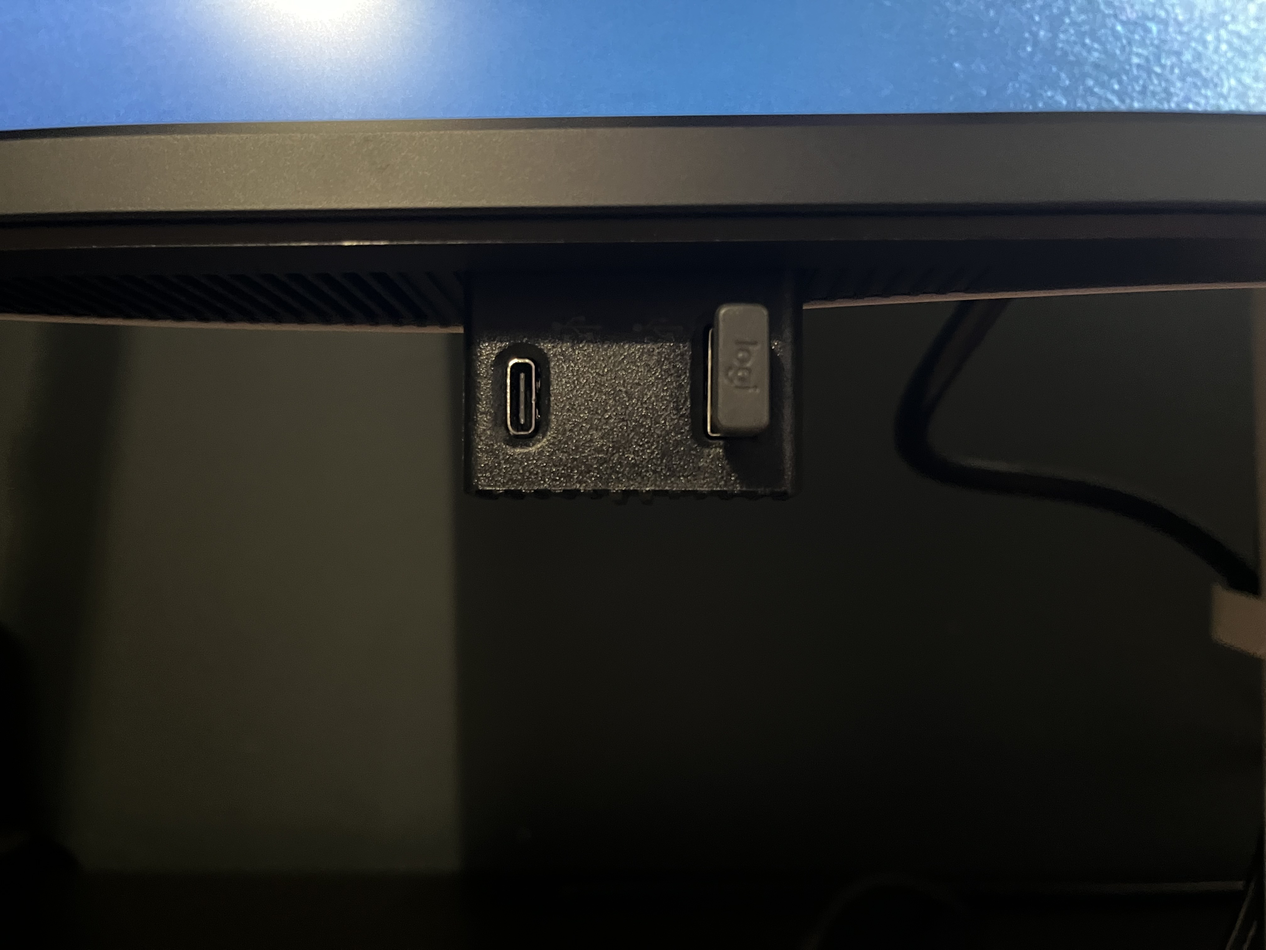 The little pop down section in the front of the monitor. There's a USB-C port and a USB-A port that's occupied by a small wireless reciever. It has "logi" on it.