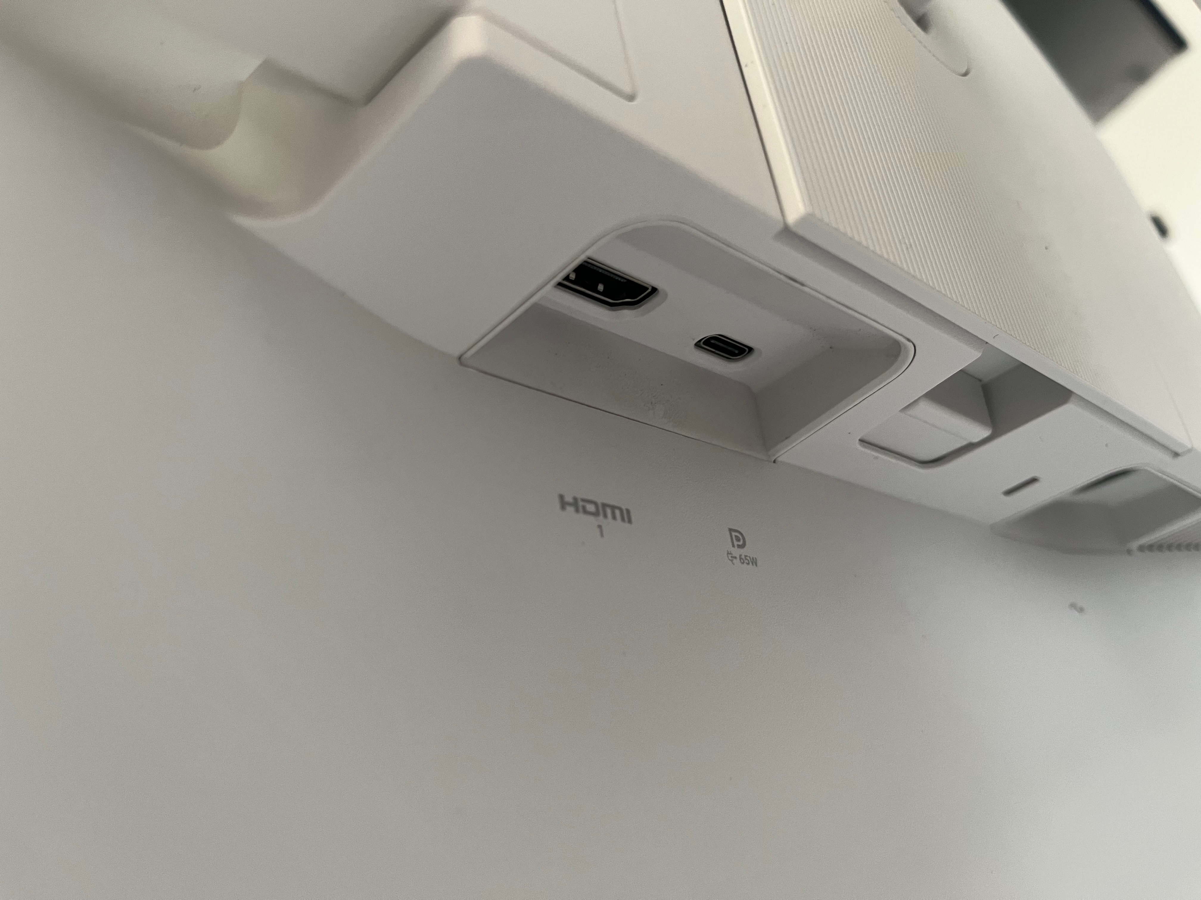 The underside of the back of the monitor. There's a HDMI port along with a USB-C port. Underneath are labels showing what they are. They are recessed.