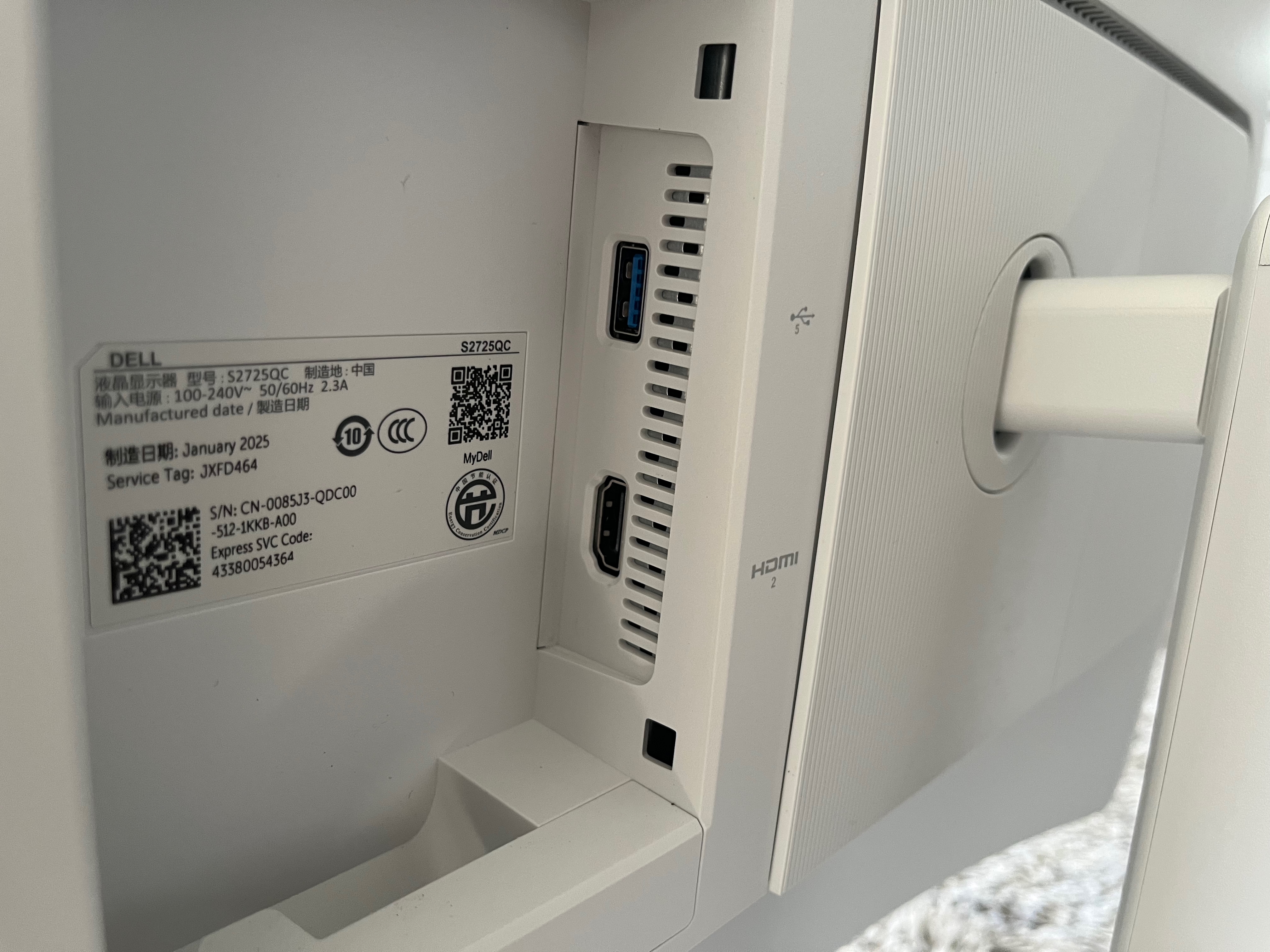 In the recessed area next to the stand are another HDMI port, along with a USB-A port. There's a label showing various bits of information about the monitor.